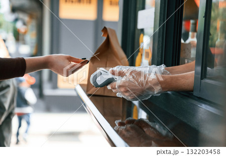Customer is making payment by credit card. Man is serving delicious street food 132203458