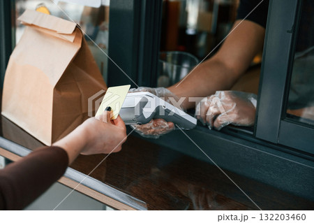 Customer is making payment by credit card. Man is serving delicious street food Customer is making payment by credit card. Man is serving delicious street food 132203460