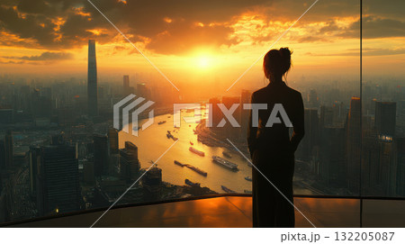 Silhouette of woman overlooking city skyline at sunset with river and boats, creating dramatic and inspiring atmosphere 132205087
