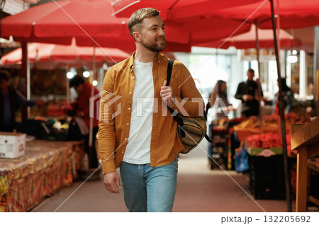 Going forward, looking at products. Handsome man is on the street market or bazaar 132205692