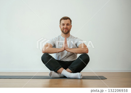 Yoga man is sitting on a mat at home Yoga man is sitting on a mat at home 132206938