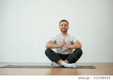 Yoga man is sitting on a mat at home Yoga man is sitting on a mat at home 132206939