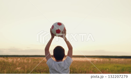 boy jumping up nature, child kid sunset, child victory, feeling victory, people ball, hands raised up sunny sky victory, back view boy holding ball in open field, boy holding soccer ball at sunset 132207279