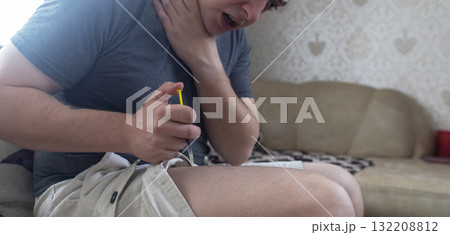 A man injects himself with adrenaline into his thigh during anaphylactic shock. First aid for allergies, emergency medical care for an allergic reaction. 132208812