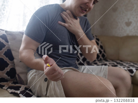 A man injects himself with adrenaline into his thigh during anaphylactic shock. First aid for allergies, emergency medical care for an allergic reaction. A man injects himself with adrenaline into his thigh during anaphylactic shock. First aid for allergies, emergency medical care for an allergic reaction. 132208818