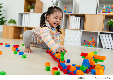 toddler girl playing building blocks or plastic bricks toy at home toddler girl playing building blocks or plastic bricks toy at home 132209425