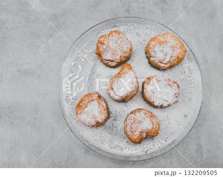 Delicious baursaki sprinkled with icing sugar on glass plate in prague copy space 132209505