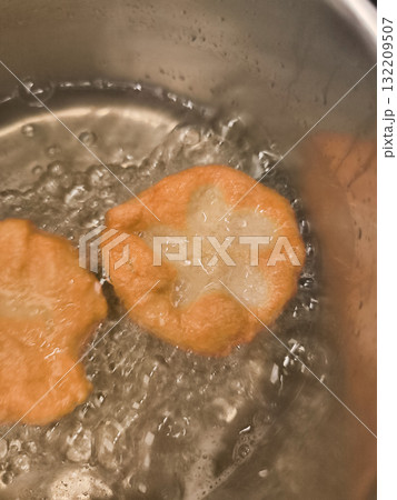 Frying baursaki, traditional fried dough pastry from central asia, in prague Frying baursaki, traditional fried dough pastry from central asia, in prague 132209507