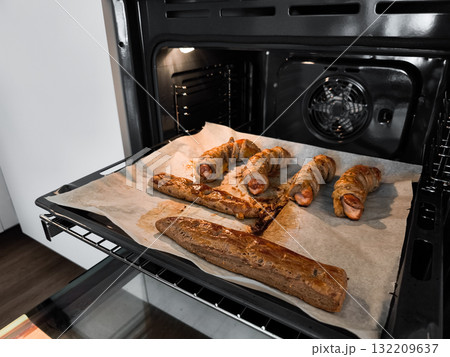 Sausages and meatloaf baking in modern oven on baking paper in prague kitchen leafy multigrain dough Sausages and meatloaf baking in modern oven on baking paper in prague kitchen leafy multigrain dough 132209637