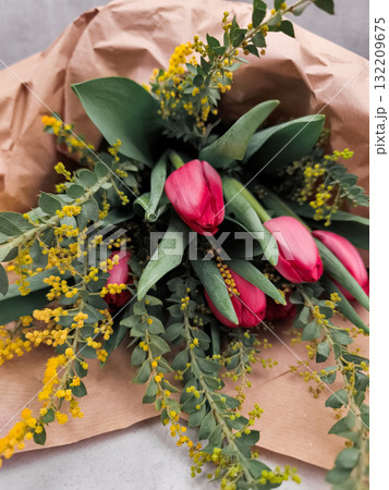 Bouquet of pink tulips and yellow mimosa wrapped in brown paper mothers day Bouquet of pink tulips and yellow mimosa wrapped in brown paper mothers day 132209675