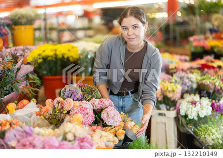 Girl salesman takes out bunch of hydrangea from showcase Girl salesman takes out bunch of hydrangea from showcase 132210149