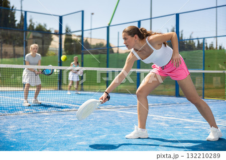 Woman standing on court and playing paddle tennis Woman standing on court and playing paddle tennis 132210289