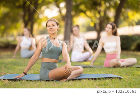 Yoga lesson visitors girls perform padmasana in park 132210563