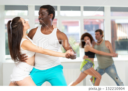 Man enjoying passioned merengue with female partner in latin dance class 132210904