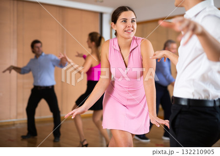 Cheerful female dancer practicing ballroom dances in ballroom Cheerful female dancer practicing ballroom dances in ballroom 132210905
