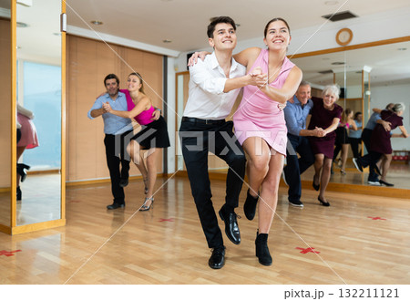 Young couple dancing jive during group training Young couple dancing jive during group training 132211121