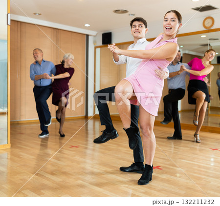 Young couple dancing jive during group training Young couple dancing jive during group training 132211232