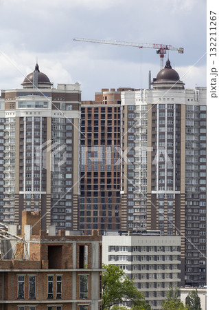 Urban High-Rise Construction with Tower Crane and Modern Apartments Urban High-Rise Construction with Tower Crane and Modern Apartments 132211267