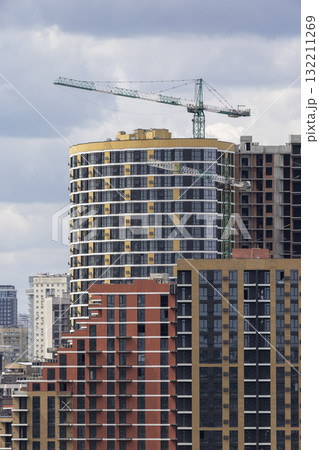 Urban High-Rise Construction with Tower Crane and Modern Apartments Urban High-Rise Construction with Tower Crane and Modern Apartments 132211269