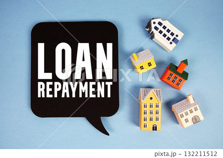 Loan Repayment text with house models on blue background Loan Repayment text with house models on blue background 132211512