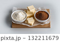 Baking Ingredients with Butter Cocoa and Flour Arranged on Wooden Board 132211679