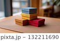 Colorful Gift Boxes Stacked on Wooden Table in Warm Natural Light 132211690