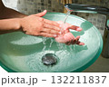 Hands of woman wash their hands in a sink with foam to wash the skin and water flows through the hands. Concept of health, cleaning and preventing germs and coronavirus from contacting hands 132211837