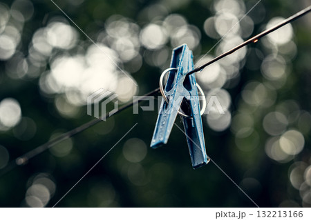 Blue Clothespin Hanging on a Wire with Bokeh Background 132213166