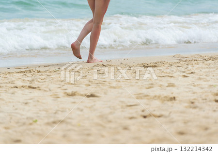 Cheerful asian woman barefoot walking on tropical summer beach. Woman walking along wave of sea water and sand on the beach. Enjoyment barefoot walk outdoor with freedom. Relaxation Travel Concept. Cheerful asian woman barefoot walking on tropical summer beach. Woman walking along wave of sea water and sand on the beach. Enjoyment barefoot walk outdoor with freedom. Relaxation Travel Concept. 132214342