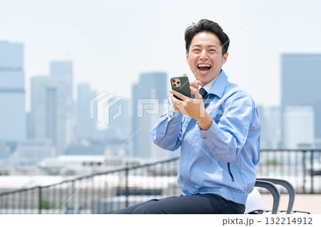 作業服の男性　スマホ　笑う 132214912