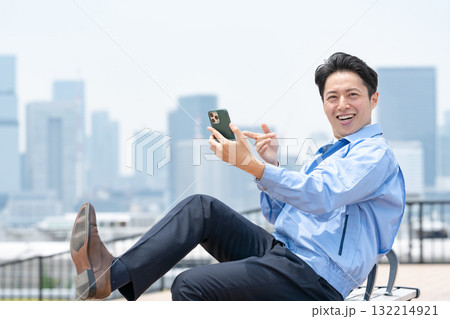 作業服の男性　スマホ　笑う 132214921