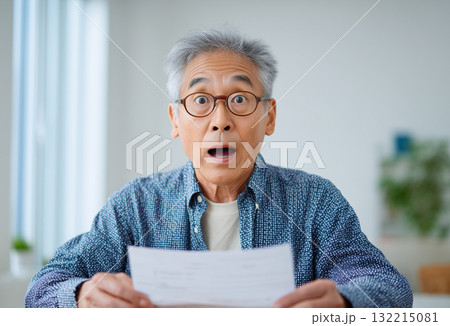 通知書を見て驚くシニア男性のリアルな表情 通知書を見て驚くシニア男性のリアルな表情 132215081