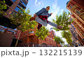 Young man jumping high between urban buildings in denim jacket and boots 132215139