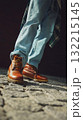 Brown leather boots and light jeans on cobblestone street in urban sunlight 132215145