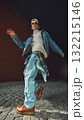 Young man in denim jacket walking confidently under city arch with modern attitude 132215146