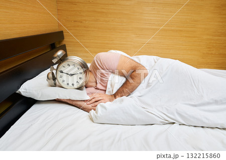 Man with alarm clock instead of head sleeping in bed. Morning concept 132215860
