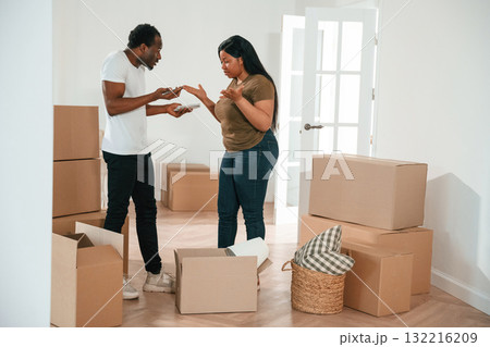 Having a quarrel. African American couple are moving into new house Having a quarrel. African American couple are moving into new house 132216209