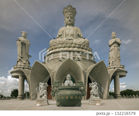 A large white marble statue of Guanyin of the Goddess of Mercy. It is seated on a celestial platform. A large white marble statue of Guanyin of the Goddess of Mercy. It is seated on a celestial platform. 132216579