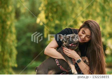 Embracing the animal. Young pretty woman is with her dog in the park 132216655