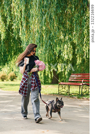 Hawing a walk. Young pretty woman is with her dog in the park 132216699