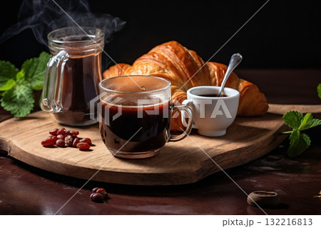 a cup of coffee and a fresh croissant, coffee beans and coarse cloth, still life on a dark background 132216813
