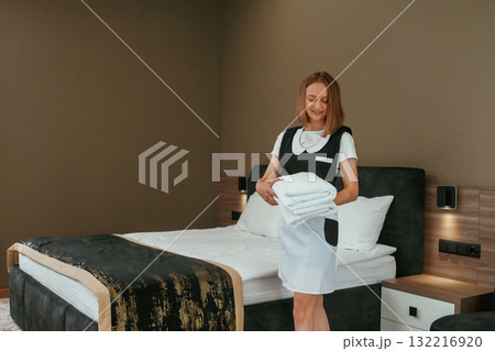 New fresh cloth. Young chambermaid is in hotel room New fresh cloth. Young chambermaid is in hotel room 132216920