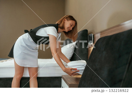 New fresh cloth. Young chambermaid is in hotel room 132216922