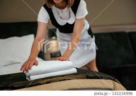 Cloth in hands, working. Young chambermaid is in hotel room 132216996