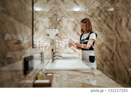 Bathroom cleaning. Young chambermaid is in hotel room Bathroom cleaning. Young chambermaid is in hotel room 132217103