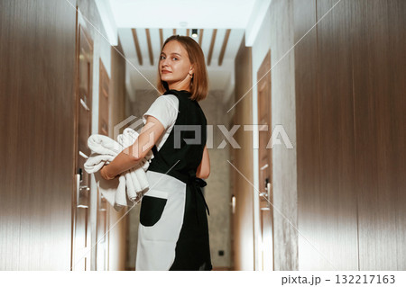 Ready for work. Chambermaid is standing in the hotel corridor 132217163