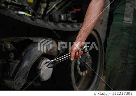 Holding wrench. Mechanic's hand fixing machinery in workshop Holding wrench. Mechanic's hand fixing machinery in workshop 132217398