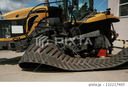 Industrial yellow bulldozer with damaged rubber track in repair yard Industrial yellow bulldozer with damaged rubber track in repair yard 132217405