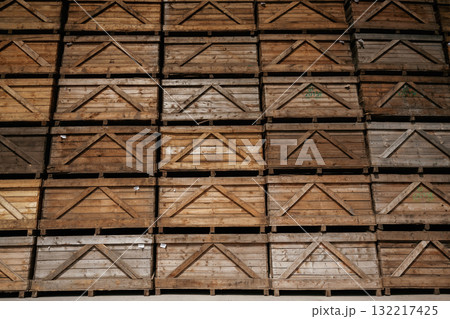 Stacked wooden crates in an organized warehouse setting Stacked wooden crates in an organized warehouse setting 132217425