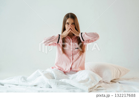 Rest conception, waking up, on the white blanket. Young pretty woman is against background in the studio Rest conception, waking up, on the white blanket. Young pretty woman is against background in the studio 132217688